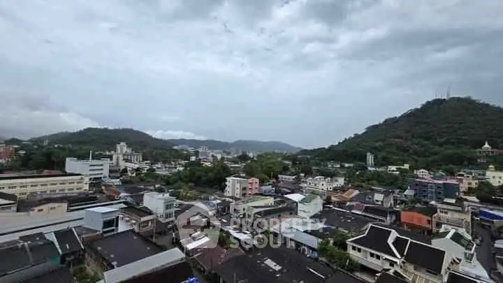 Stunning panoramic view of a cityscape with lush green hills in the background.