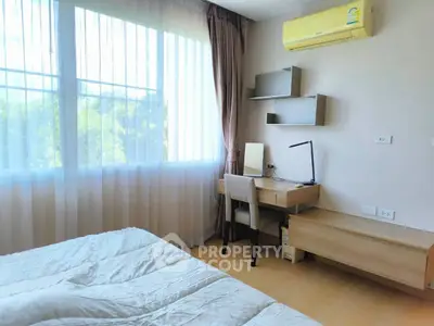 Bright bedroom with large window, modern desk, and air conditioning unit.