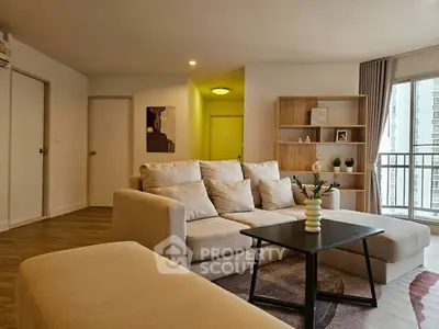 Spacious living room with cozy sofa and modern decor, featuring a balcony view.