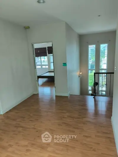 Spacious hallway with wooden flooring and natural light