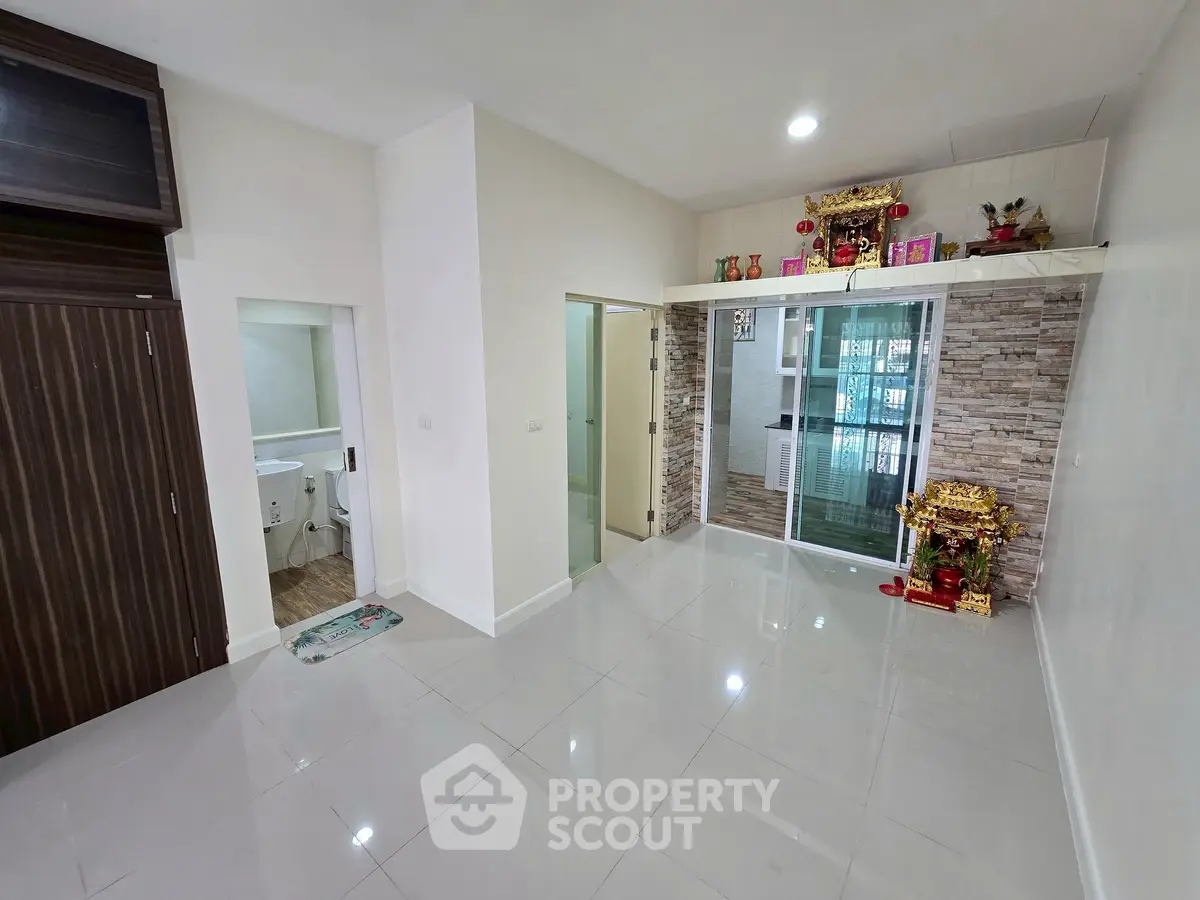 Spacious living room with modern tile flooring and decorative wall accents in a contemporary apartment.