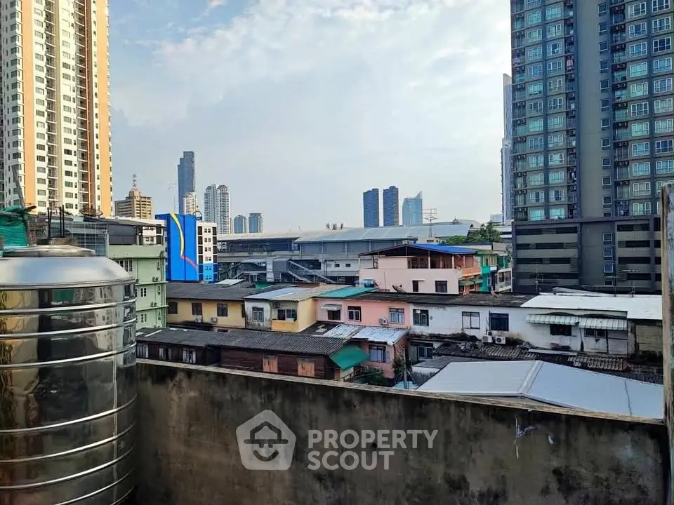 Urban skyline view with high-rise buildings and residential rooftops, showcasing city living.