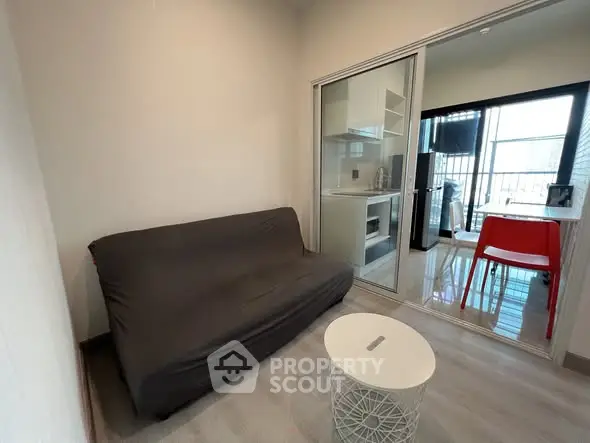 Cozy living room with modern kitchenette and balcony view