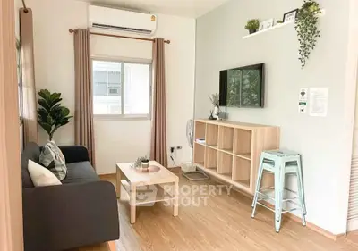 Charming living room with modern decor and natural light, featuring a cozy sofa and stylish shelving.