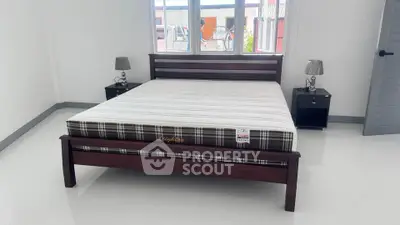 Spacious bedroom with elegant wooden bed frame and modern decor