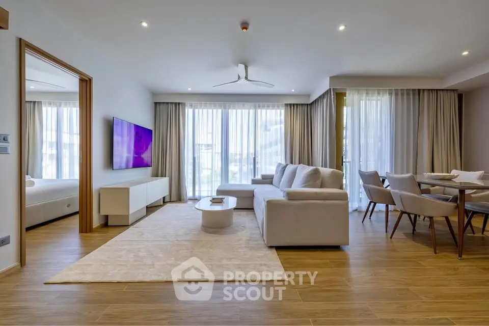 Spacious modern living room with elegant decor and large windows offering natural light.