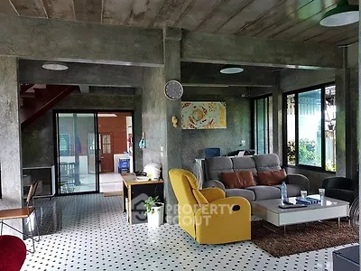 Modern industrial-style living room with unique concrete walls and colorful furniture.