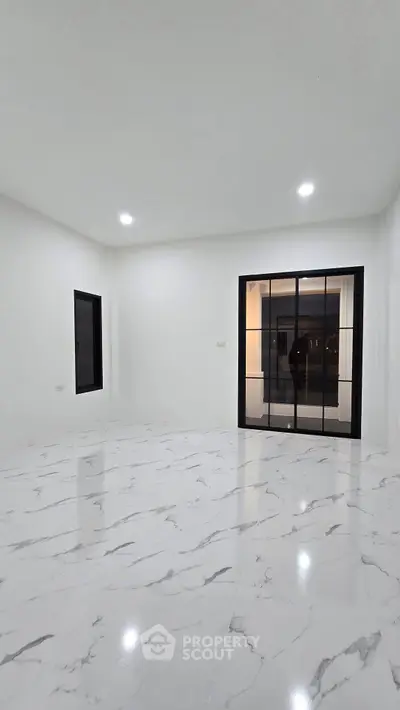 Spacious modern living room with marble flooring and large windows for natural light.