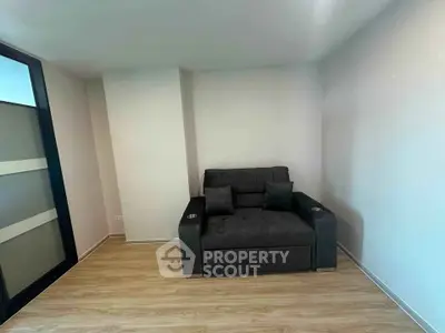 Cozy living room with modern armchair and wooden flooring, perfect for relaxation.