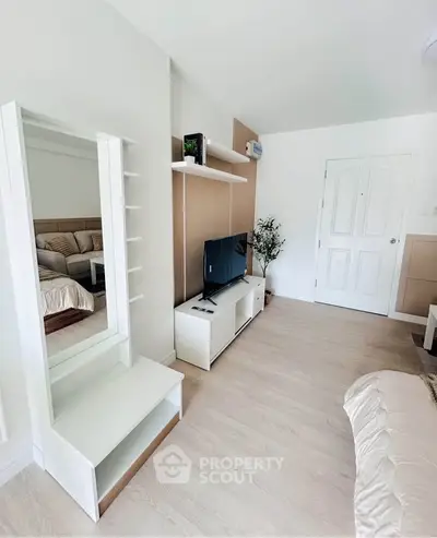 Modern living room with stylish decor and cozy ambiance, featuring a sleek TV unit and comfortable seating.