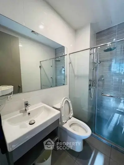 Modern bathroom with glass shower and sleek fixtures in a contemporary home.