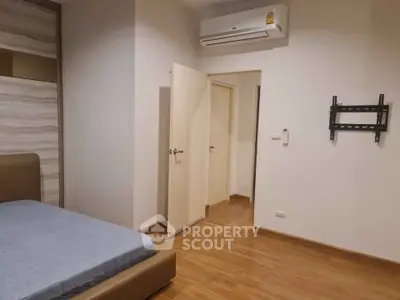 Spacious bedroom with modern air conditioning and wooden flooring