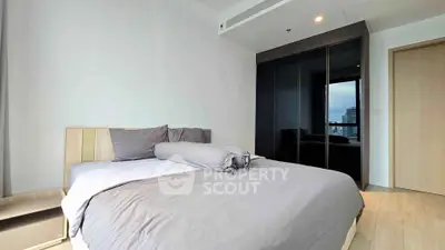 Modern bedroom with sleek design and city view, featuring a cozy bed and stylish wardrobe.