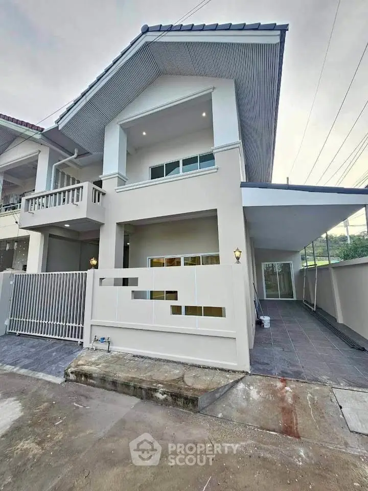 Modern two-story house with sleek design and spacious driveway in a suburban neighborhood.