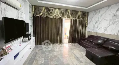 Luxurious living room with marble walls, elegant drapes, and modern entertainment setup.