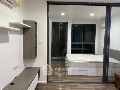 Modern bedroom with glass partition and wooden flooring in stylish apartment