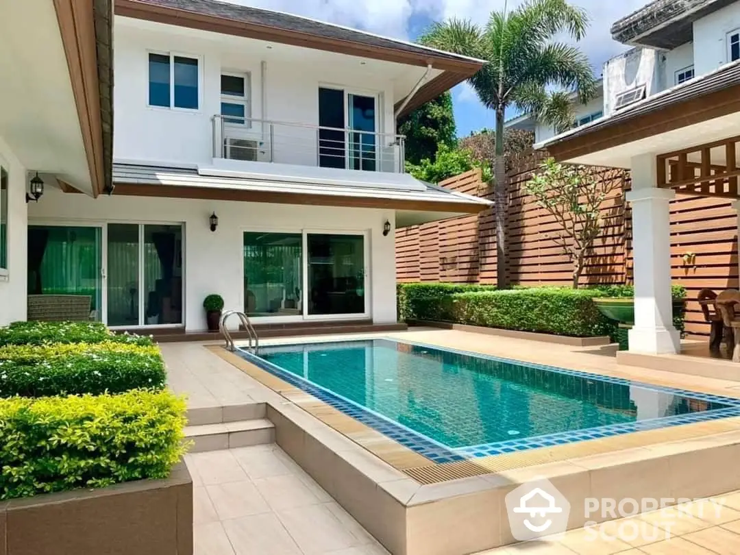 Luxurious two-story residence with a sparkling private pool and manicured garden, featuring a spacious patio and modern architecture.