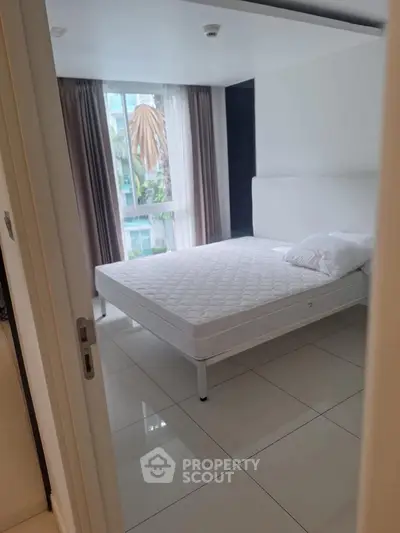 Bright bedroom with large window and minimalist decor in modern apartment.