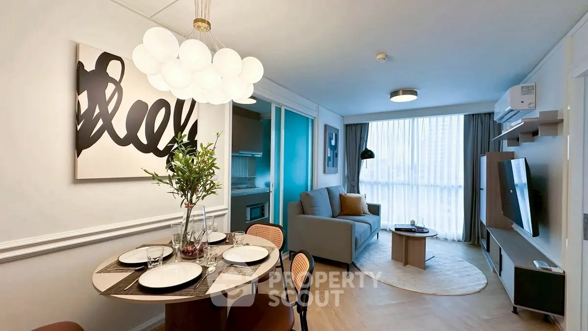 Modern living room with stylish decor and dining area, featuring elegant lighting and large window.