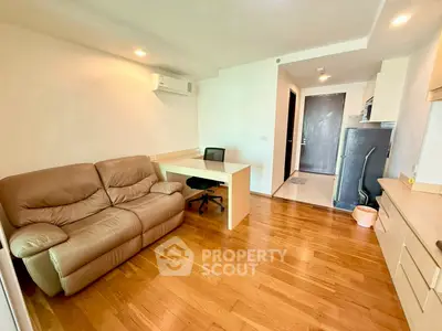 Modern living room with wooden flooring and cozy furniture in a stylish apartment.