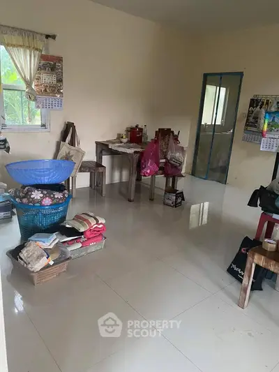 Spacious living room with tiled flooring and natural light, ideal for cozy gatherings.