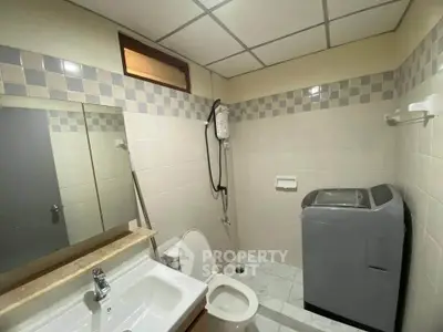 Compact bathroom with washing machine and modern fixtures