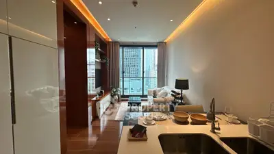 Modern living room with city view, open kitchen, and elegant decor in a high-rise apartment.