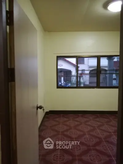 Cozy small room with tiled floor and window view of neighboring house.