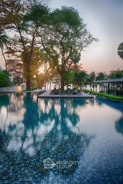 Luxurious poolside view with serene surroundings and lush greenery at sunset.