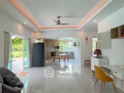 Spacious open-plan living room with modern kitchen and garden view, perfect for family gatherings.