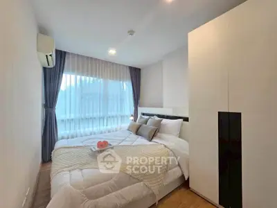 Cozy bedroom with large window and modern decor, perfect for relaxation.