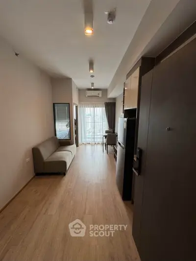 Modern apartment interior with wooden flooring and compact living space.