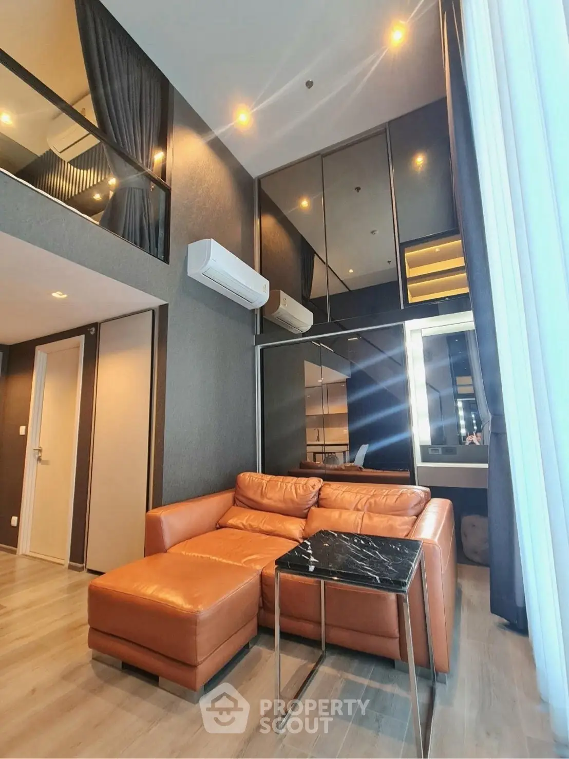 Modern living room with high ceiling, leather sofa, and stylish decor