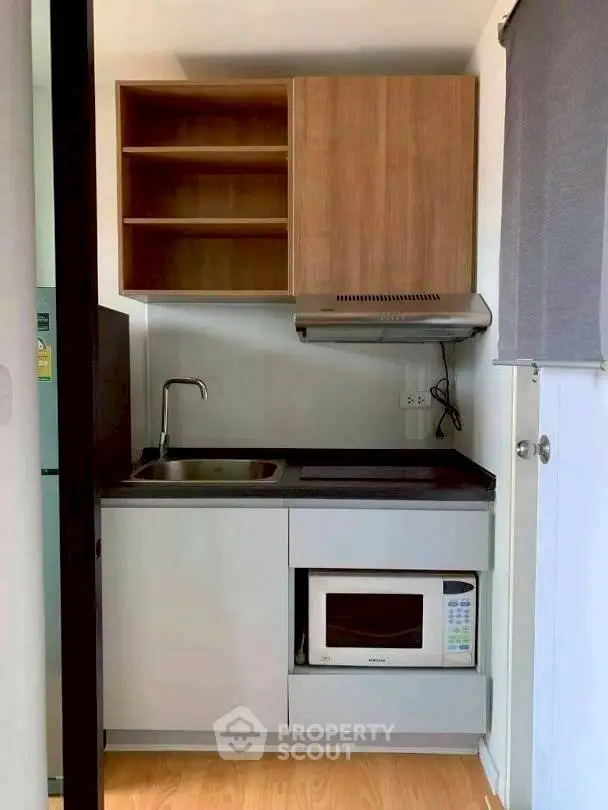 Compact modern kitchen with microwave and wooden cabinets