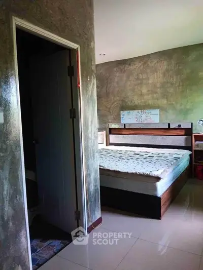 Cozy bedroom with modern decor and polished flooring, featuring a comfortable bed and stylish wall design.