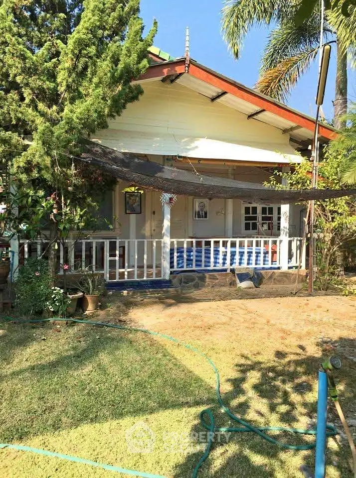 Charming bungalow with lush garden and inviting porch in serene setting.