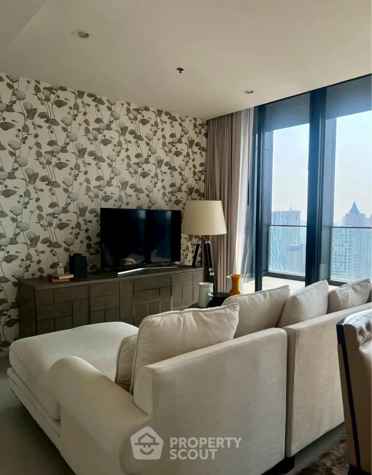 Stylish living room with floral wallpaper and city view balcony in modern apartment