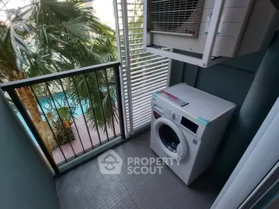 Compact balcony with washing machine and pool view, ideal for urban living.