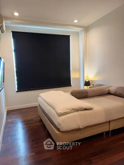 Cozy bedroom with modern decor and large window with blackout blinds.