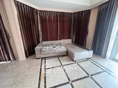 Spacious living room with elegant marble flooring and cozy sectional sofa.