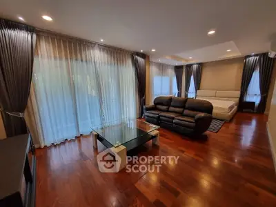 Spacious living room with elegant hardwood floors and modern furniture