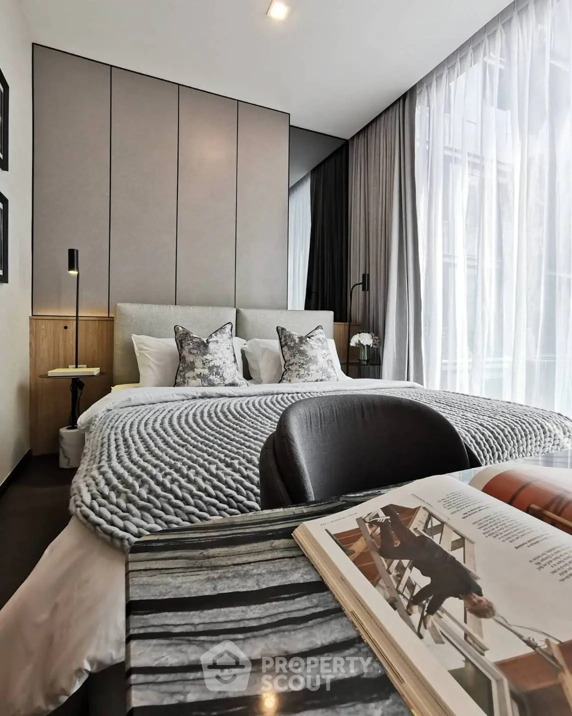 Modern bedroom with cozy knit blanket and large window for natural light