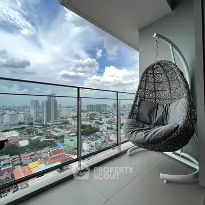 Stunning city view from modern balcony with cozy hanging chair.