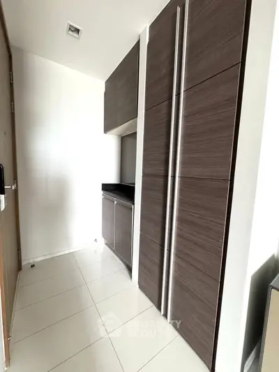 Modern minimalist kitchen with sleek cabinetry and tiled flooring