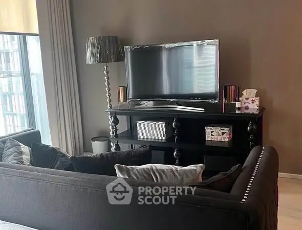 Modern living room with stylish decor and large TV, perfect for relaxation.