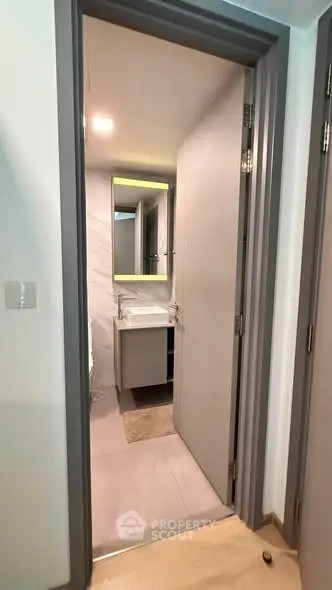 Modern bathroom with sleek design and illuminated mirror in a contemporary apartment.