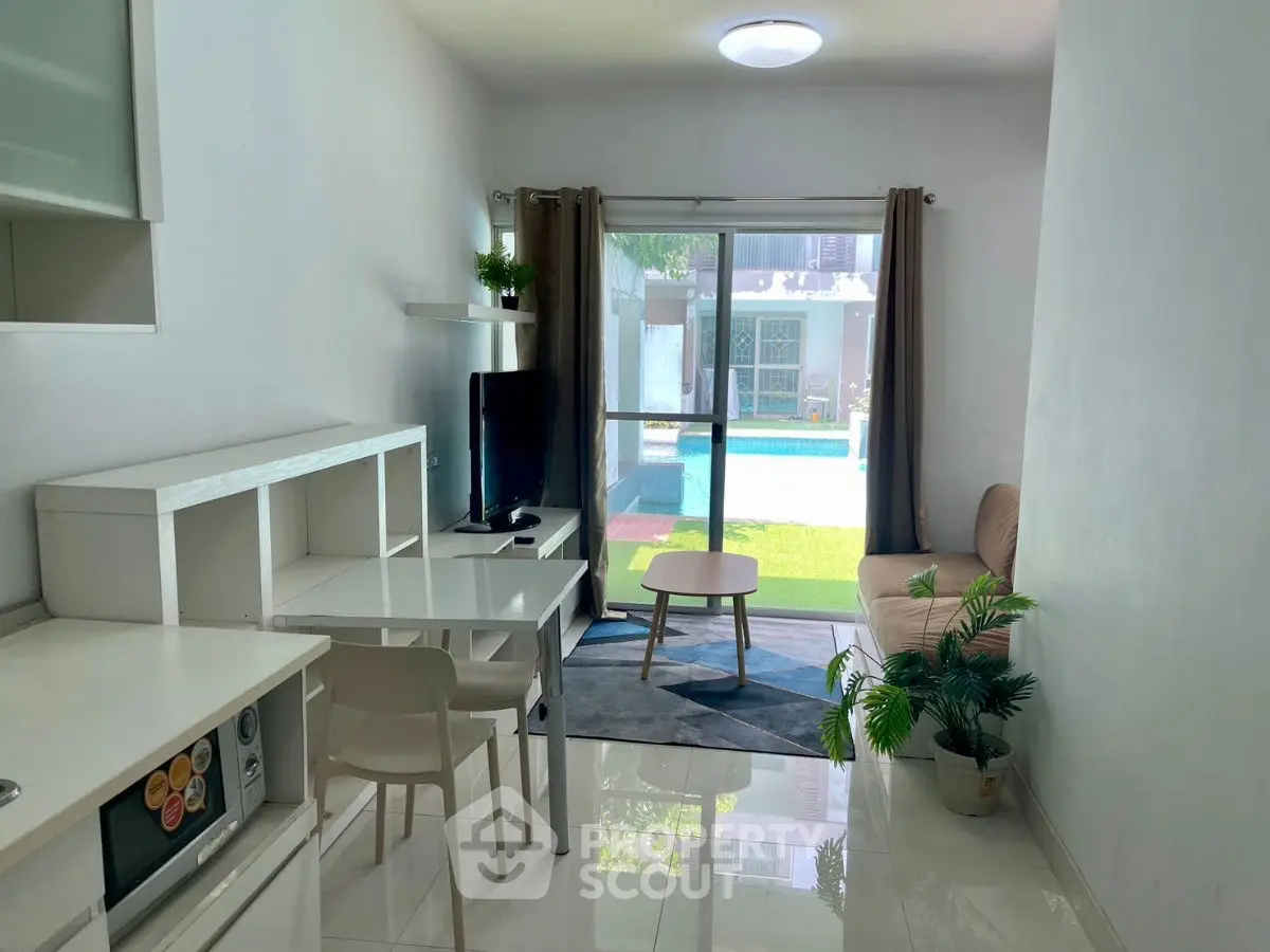 Modern living room with pool view, sleek furniture, and natural light.
