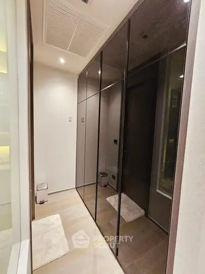 Sleek modern hallway with glossy black cabinets and ambient lighting