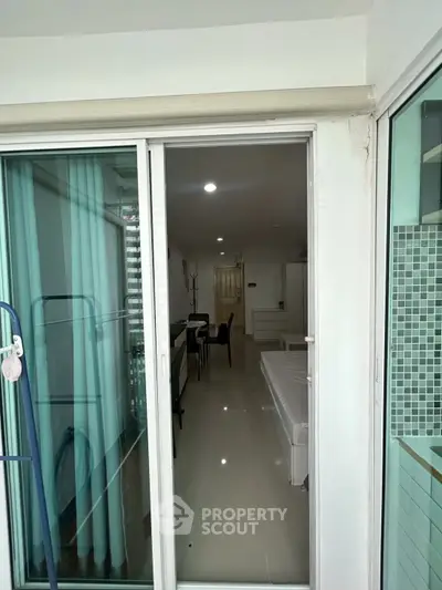 Modern apartment with sliding glass doors leading to a bright interior featuring dining and living areas.