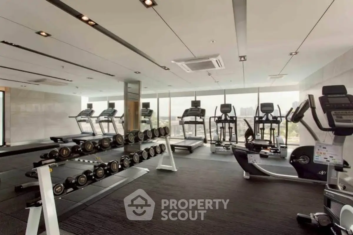Modern gym with state-of-the-art equipment and panoramic city views, perfect for fitness enthusiasts.